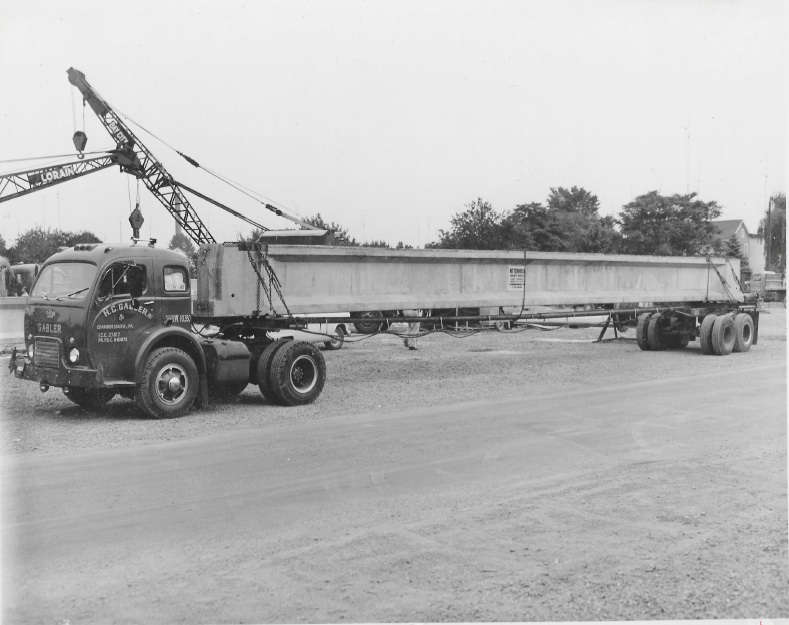 Concrete slab being transported on an extended bed truck.